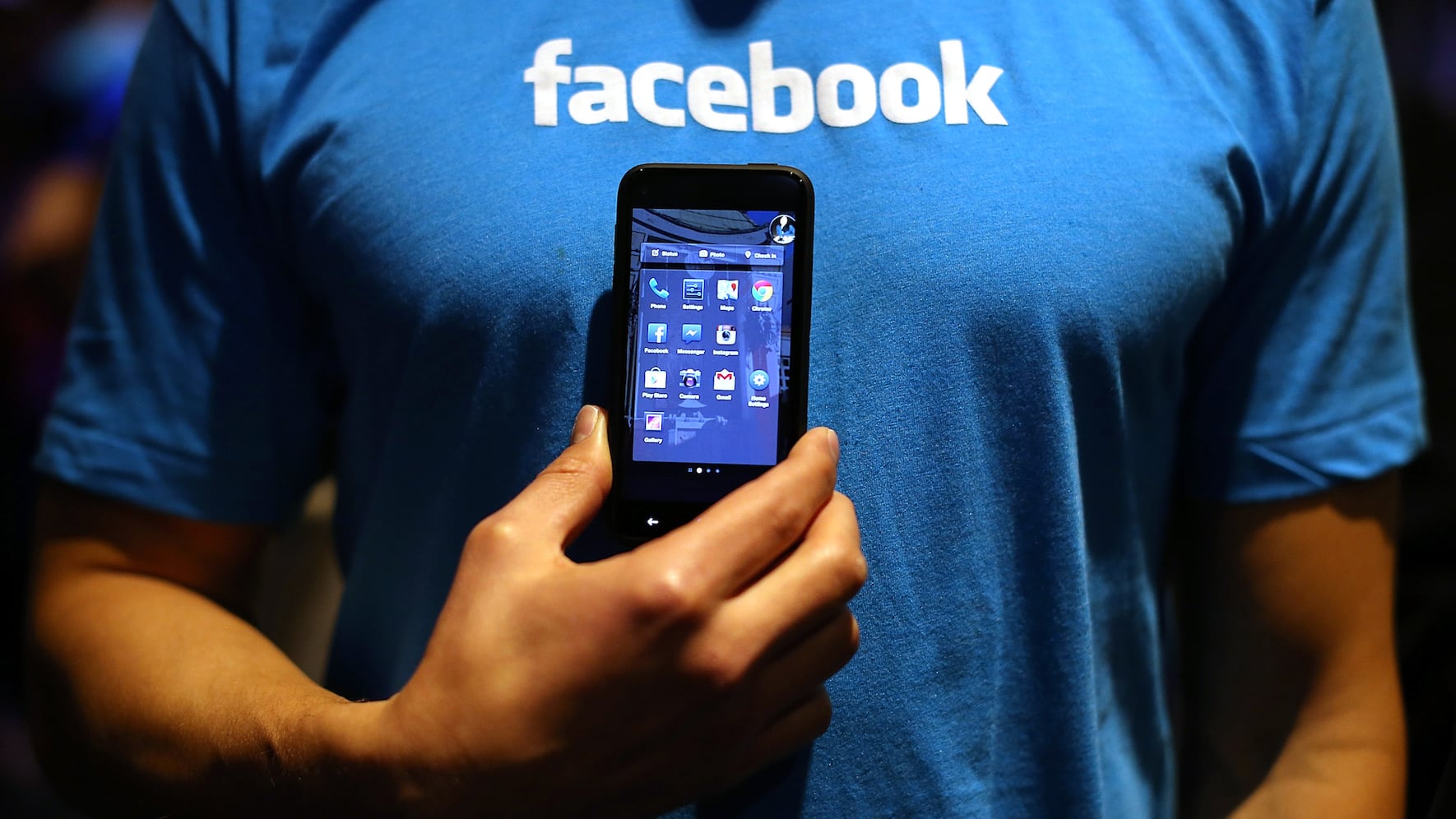 MENLO PARK, CA - APRIL 04: A Facebook employee holds a phone that is running the new "Home" program during an event at Facebook headquarters during an event at Facebook headquarters on April 4, 2013 in Menlo Park, California. Facebook CEO Mark Zuckerberg announced a new product for Android called Facebook Home as well as the new HTC First phone that will feature the new software. (Photo by Justin Sullivan/Getty Images)