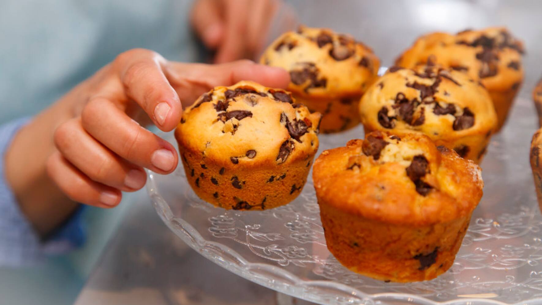 Pastry: muffins with chocolate sprinkles. Woman taking a muffin (Photo by: Andia/UIG via Getty Images)