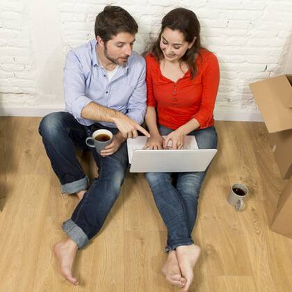 Mietkaution: wie vergleichen? pärchen sitzt am Boden vor Latop