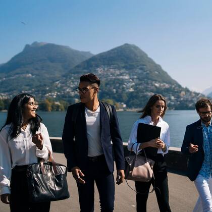 Seminare und Kongresse ermöglichen Austausch und Inspiration Geschäftsleute laufend in Lugano mit Monte Brè im Hintergrund