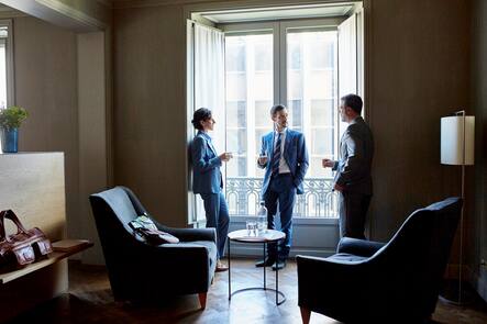 Business people discussing while standing at window in hotel room