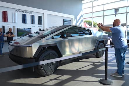 epa11006474 People view and take pictures of a Tesla Cybertruck on display at Tesla in Buena Park, California, USA, 01 December 2023. After four years of delays and complications, the Tesla Cybertruck was released on 01 December by Tesla CEO Elon Musk. The cheapest rear-wheel drive model won't be available until 2025 at the earliest, with a price starting at 60,990 US dollars. EPA/ALLISON DINNER