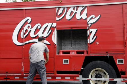 Ein Zusteller schliesst die Fächer eines Coca-Cola-Lkw.