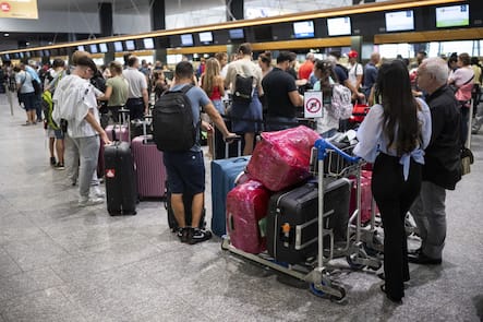 Menschen warten am Check-In Schalter auf ihren Abflug in die Ferien, aufgenommen am Samstag, 8. Juli 2023 auf dem Flughafen in Zuerich. (KEYSTONE/Ennio Leanza)