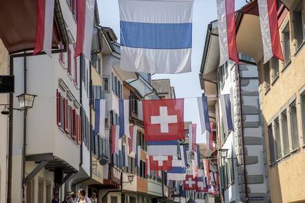 Zuger Fahnen und Schweizer Fahnen schmuecken eine Gasse in der Zuger Altstadt am Montag, 26. Juni 2023 in Zug. (KEYSTONE/Urs Flueeler).