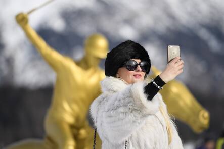 A visitor in fur coat takes a selfie during the Snow Polo World Cup Tournament, on Saturday, January 28, 2017, in St. Moritz, Switzerland. (KEYSTONE/Gian Ehrenzeller)