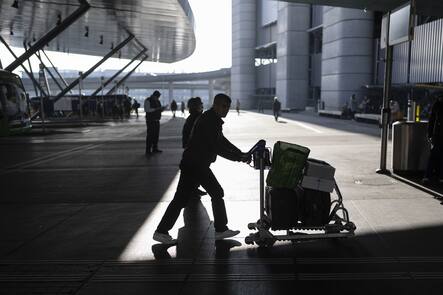 Eine Person schiebt einen Wagen mit Gepaeck in Richtung Check-in am Sonntag, 14. Januar 2024 am Flughafen Zuerich in Kloten. (KEYSTONE/Gaetan Bally)