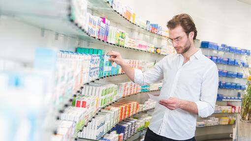 EU droht Medikamentenmangel in der Schweiz zu verstärken Apotheker sucht Medikamente aus einem Regal