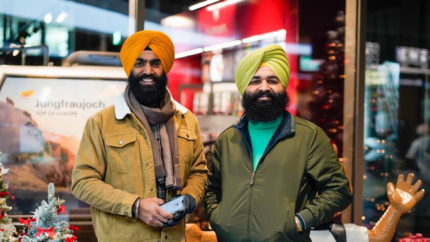 Jagdeep und Mohd aus Indien posieren am Terminal mit ihren Turbanen