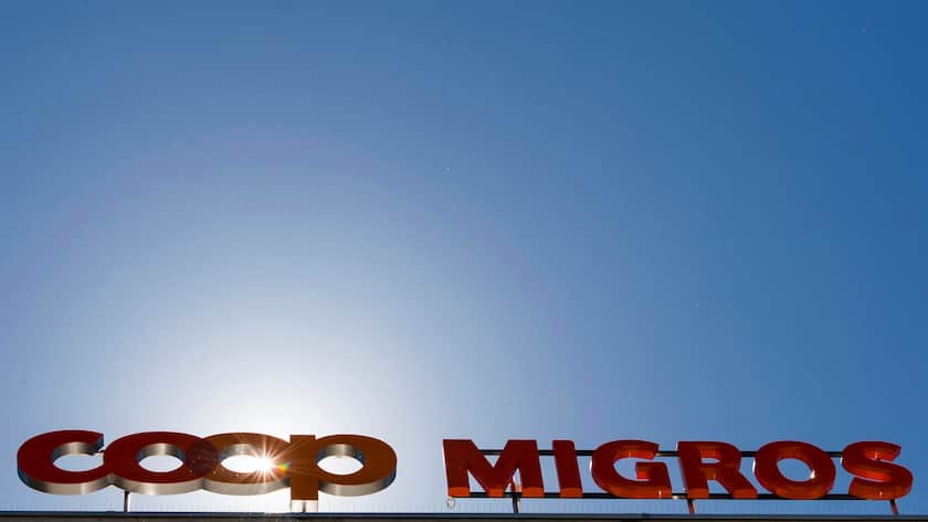 Migros oder Coop – wer gewinnt das grosse Punkte-Duell? Le logo de la Coop et le logo de la Migros sont photographies cote a cote sur un batiment commercial commun ce mardi 23 aout 2016 sur la place de la Sallaz a Lausanne. (KEYSTONE/Jean-Christophe Bott)