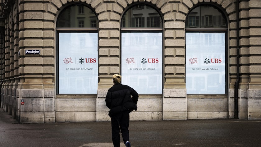 A man walks past a building with screens showing a logo of Swiss Bank UBS and the logo of Swiss Football Association SFV with the words "A bank like Switzerland" at Zurich's Paradeplatz on Monday, June 10, 2024 in Zurich, Switzerland. (KEYSTONE/Michael Buholzer)