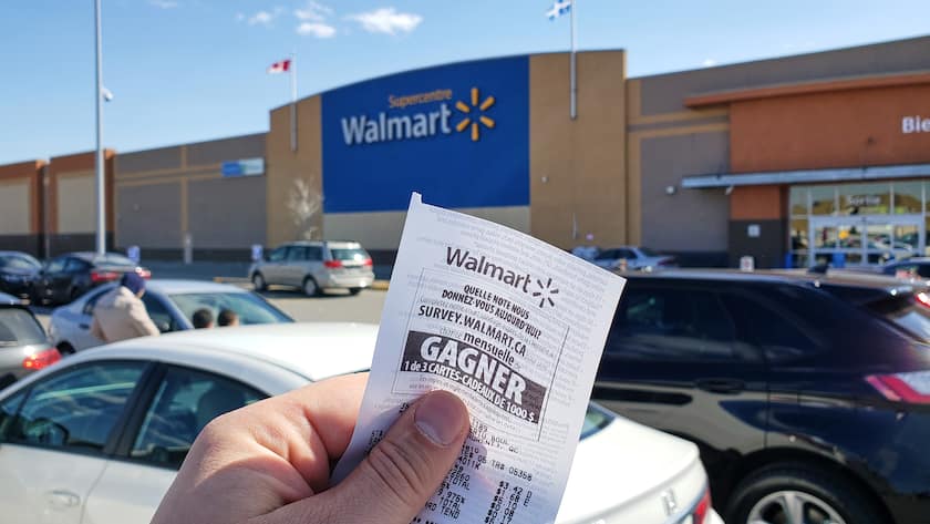MONTREAL, CANADA - APRIL 30, 2019: A hand holding a Walmart receipt in front of Walmart store. Walmart is an American retail corporation that operates a chain of hypermarkets and discount stores