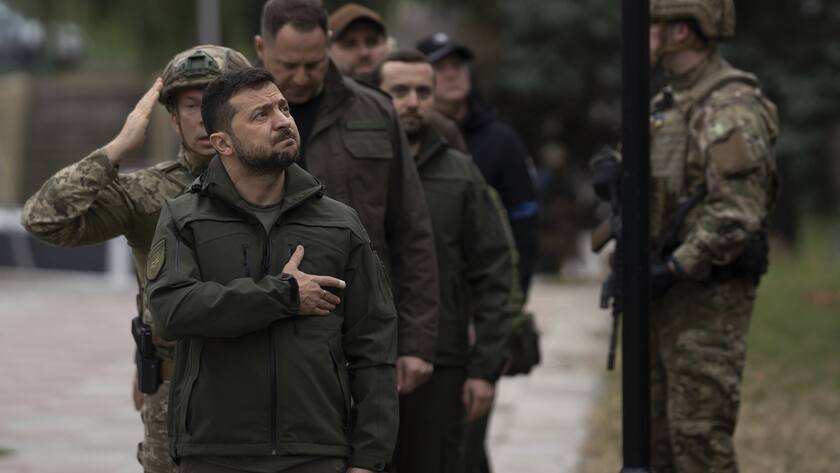 Ukrainian President Volodymyr Zelenskyy takes part in a national flag-raising ceremony in Izium, Ukraine, Wednesday, Sept. 14, 2022. Zelenskyy visited the recently liberated city on Wednesday, greeting soldiers and thanking them for their efforts in retaking the area, as the Ukrainian flag was raised in front of the burned-out city hall building. (AP Photo/Leo Correa)
