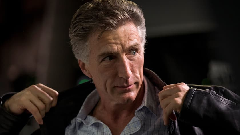 Bracken Darrell, CEO von Logitech, hält seine Jacke am Kragen, um sie zu richten.