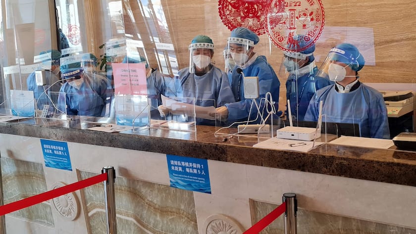 Flughafenpersonal in Peking: Ankommende müssen künftig nur noch fünf Tage in Hotelquarantäne.