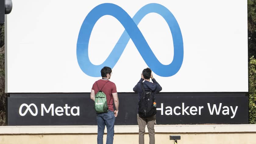 Zwei Personen mit Rücken zur Kamera vor Meta-Schild in den USA.