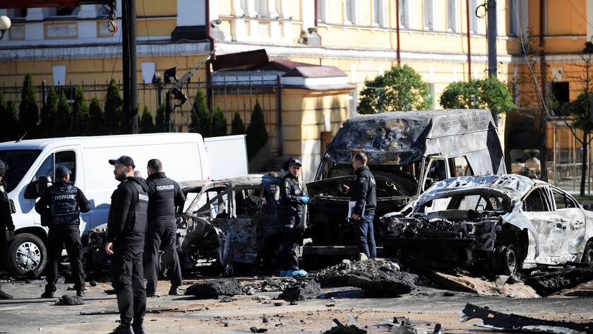 In der von russischen Raketen getroffenen Hauptstadt Kiew entfernen ukrainische Polizisten zerstörte Autos.