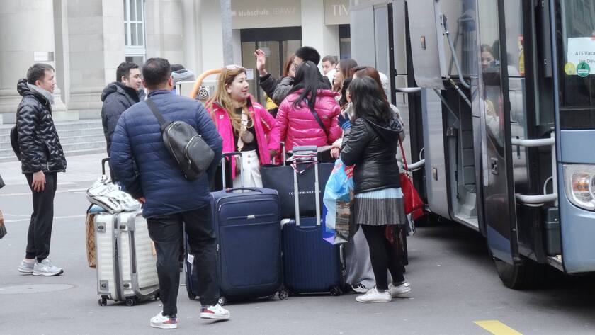 Foto Manuel Geisser 20.02.2023 Tourismusbranche Schweiz. Touristen aus Asien mit Koffer vor Reisebus *** Photo Manuel Geisser 20 02 2023 tourism industry Switzerland tourists from Asia with suitcase in front of coach