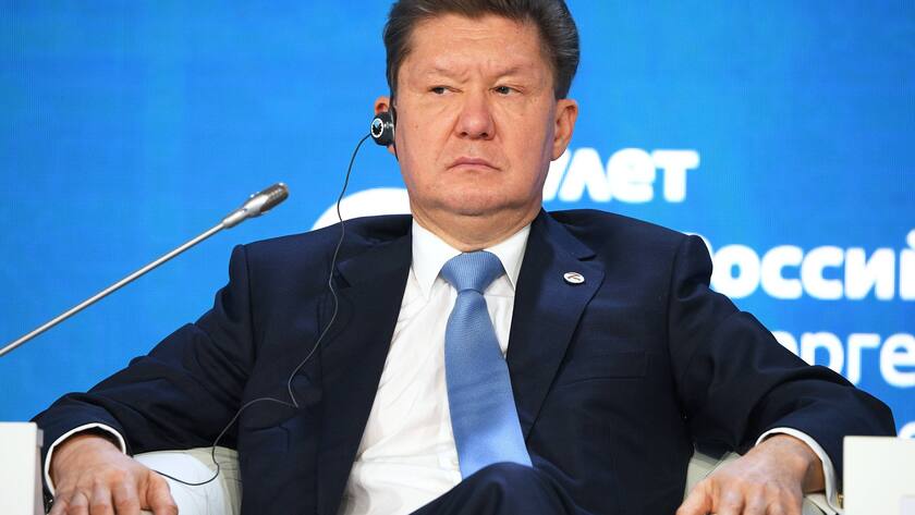 Gazprom CEO Alexey Miller sitzt in einem weissen Sessel, beide Hände auf den Lehnen und blickt zur Seite.