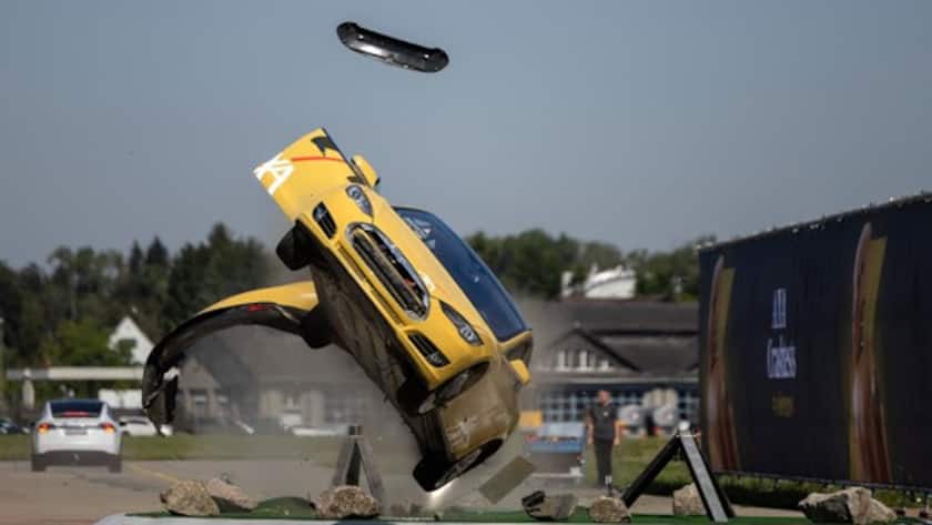 Ein Tesla kollidiert mit einem Kreisel und überschlaegt sich bei einem simulierten Unfall.