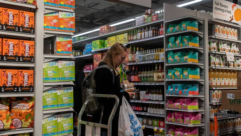 Eine Frau mit Plastiksack in einem Einkaufszentrum in den USA zwischen den Regalen.
