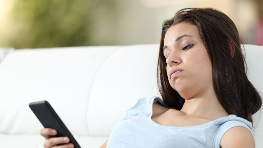 Gelangweilte Frau am Mobile