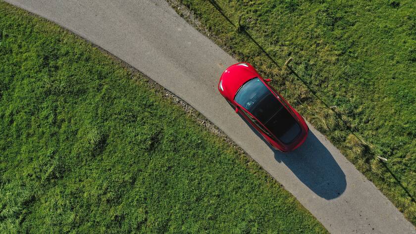 10.10.2021, Ein roter Tesla Model 3 fährt auf einer Landstrasse bei Kempten im Allgäu. 10.10.2021, Tesla auf der Landstrasse 10.10.2021, Tesla auf der Landstrasse *** 10 10 2021, A red Tesla Model 3 drives on a country road near Kempten in the Allgäu 10 10 2021, Tesla on a country road 10 10 2021, Tesla on a country road