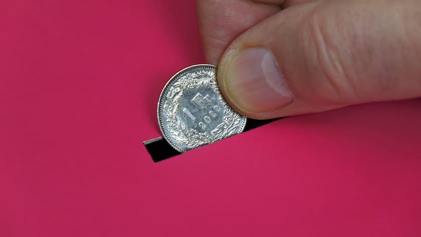 Warum der Franken gegenüber dem Euro absackt Geldkarton mit Münze Geldkarton mit Münze, 15.07.2023, Borkwalde, Brandenburg, Eine Hand steckt einen Schweizer Franken in einen roten Geldkarton. *** Money box with coin Money box with coin, 15 07 2023, Borkwalde, Brandenburg, A hand puts a Swiss franc into a red money box