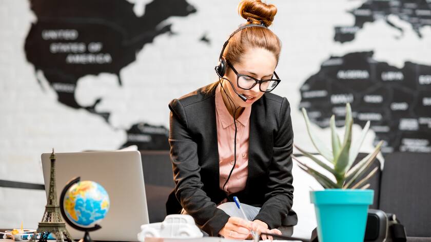 Junge Frau am Schreibtisch - Arbeiten im Ausland - Altersvorsorge