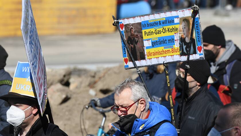 Demonstration gegen den Einmarsch Russlands in die Ukraine in Berlin. Demonstranten halten Schilder hoch u.a. mit dem Schriftzug Ich brauche und wull kein Putin-Gas-Öl-Kohle getränkt mit Ukrainischem Blut. Anti-Putin Schilder auf der Berliner Demo gegen Ukraine-Krieg *** Demonstration against Russias invasion of Ukraine in Berlin Demonstrators hold up signs with the words I dont need and dont want Putin gas oil coal soaked with Ukrainian blood Anti Putin signs at Berlin demonstration against Ukraine war