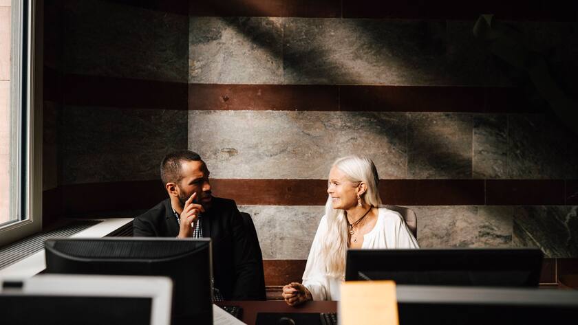 Business colleagues discussing while sitting at desk during meeting in office Sweden, Stockholm, model released, property released Copyright: xMaskotx , MA92507