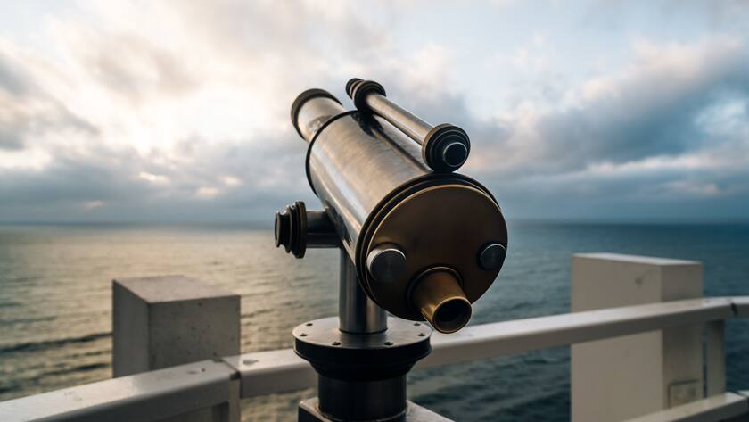 Telescope in the beach at sunset, focus on foreground