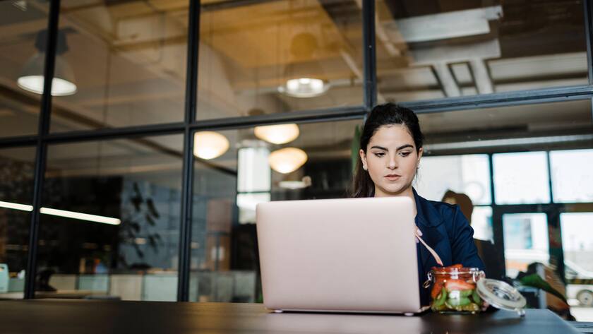 Young woman having fruits at laptop in office model released, Symbolfoto property released, DCRF01381
