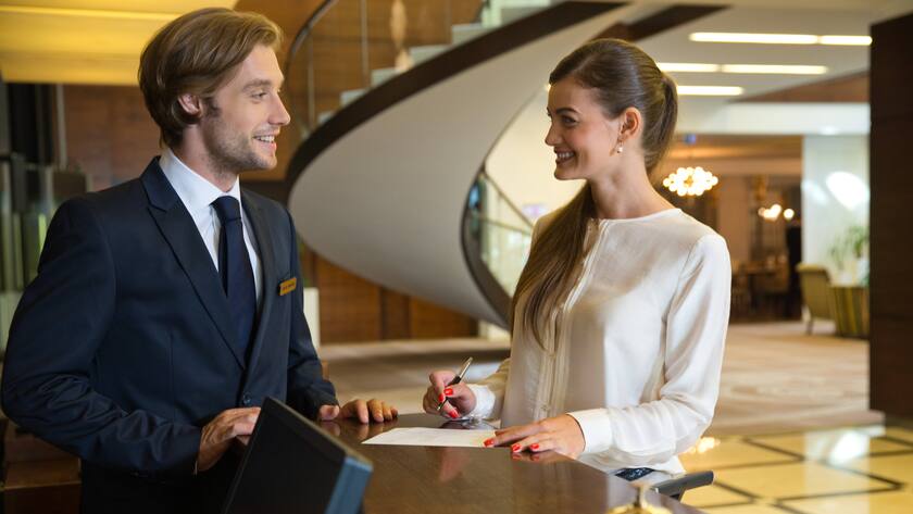 Businesswoman checking out in hotel reception.
