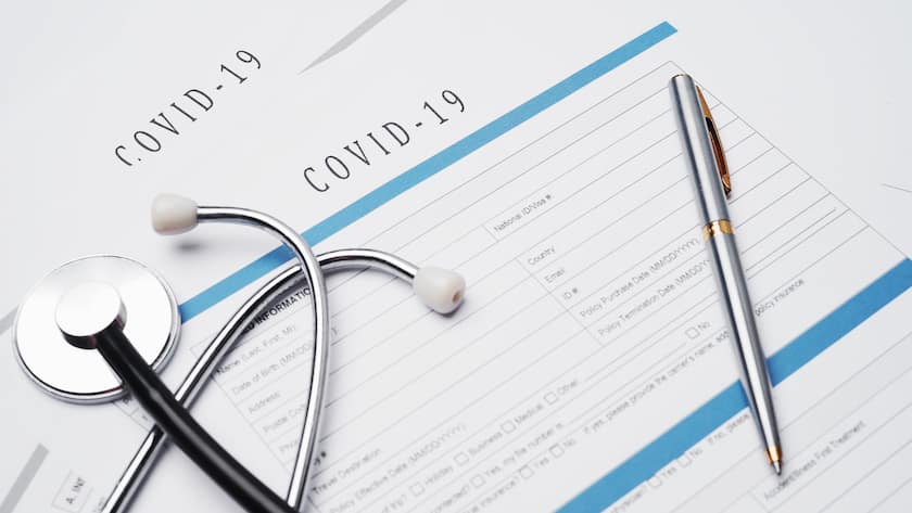 Coronavirus or COVID19 insurance policy document on desk, Health Care Insurance Plan concept.