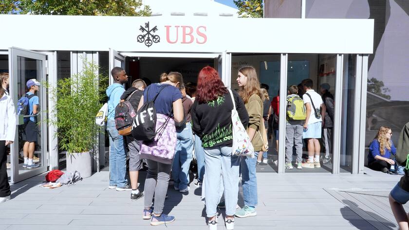 Teenager stehen in Schlange vor einer UBS.
