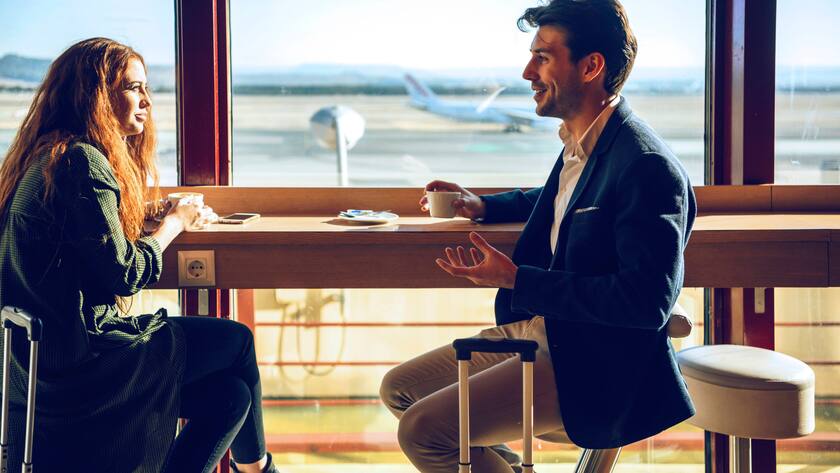 Happy business couple discussing while sitting at airport cafe model released Symbolfoto EHF00392
