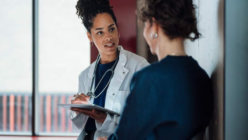 Doctor with tablet PC explaining patient in hospital model released, Symbolfoto property released, JOSEF25047