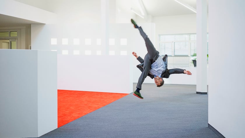 Businessman jumping mid-air on office floor