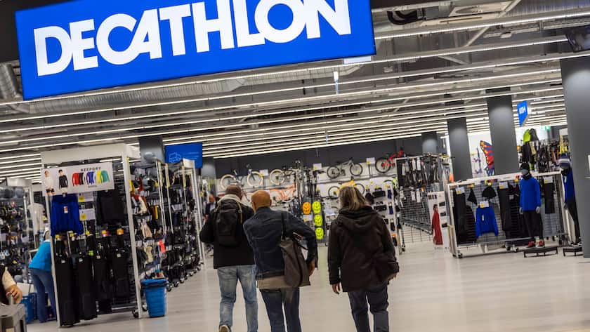 Menschen vor Decathlon Shop, darüber prangert gross das Logo in weiss auf blauem Hintergrund.