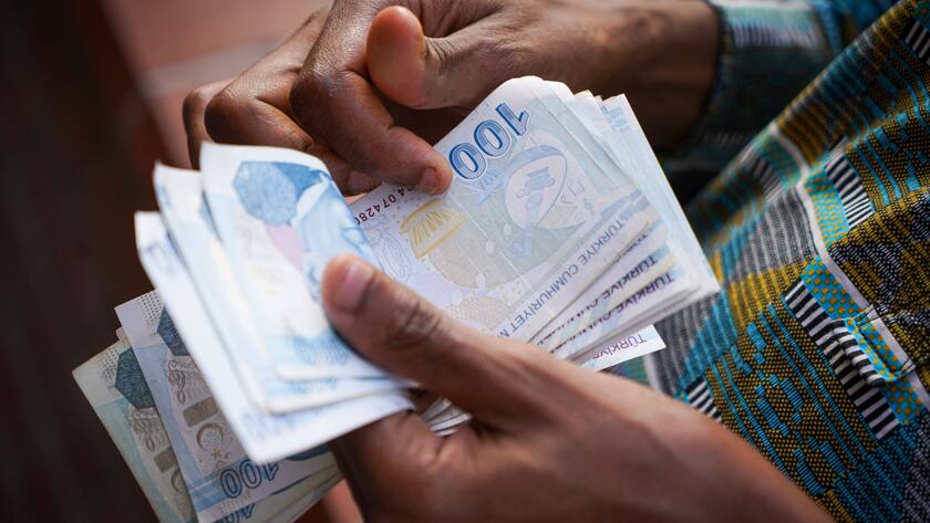 Zwei Hände zählen 100er Scheine türkischer Lira.