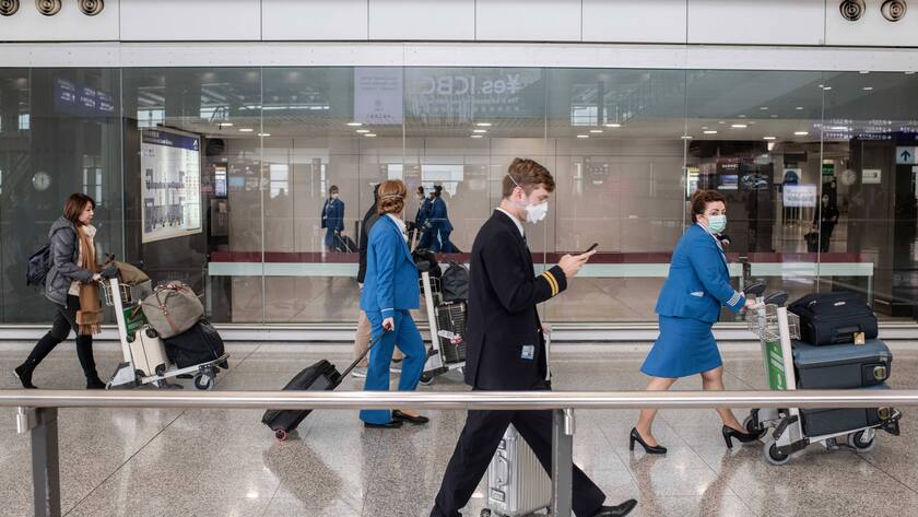 Besatzungsmitglieder von KLM mit FFP2-Masken im Ankunftsterminal des internationalen Flughafens Hongkong.