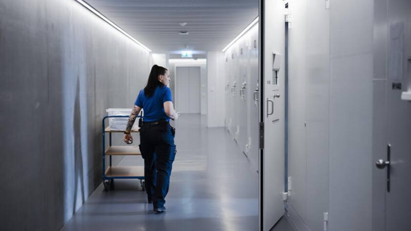 Eine Aufseherin schaut in eine Zelle im Gang eines Zellentrakts im Polizei- und Justizzentrum Zuerich (PJZ), waehrend des Testbetriebs des Gefaengnis Zuerich West (GZW)
