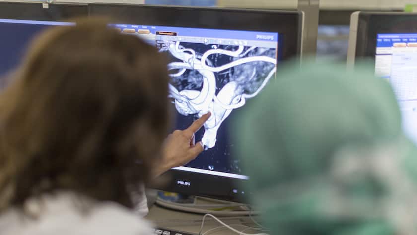 Prof. Dr. med. Isabel Wanke looks at images on a computer before she and Prof. Dr. med. Daniel Ruefenacht perform endovascular coiling to treat a brain aneurysm in the NeuroSuite operating theater at the Hirslanden Hospital in Zurich