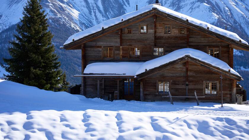 Schneefeld mit altem, dunklen Chalet mit Sprossenfenstern. Im Hintergrund verschneites Bergmassiv. Wallis, Schweiz *** Snowfield with old, dark Chalet with Mullion windows at Background Verschneites Mountain massif Valais, Switzerland 1082501895