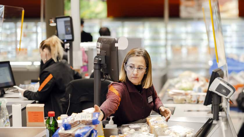 Die Verkaeuferin Stefania Kaufmann, Mitte, bedient Tammy Gross, rechts, in der Migros am Limmatplatz, am Donnerstag, 17. Februar 2022 in Zuerich. Der Bundesrat hebt per Donnerstag fast alle Corona-Massnahmen auf. Dazu gehoert auch die Maskenpflicht in Laeden, Restaurants und am Arbeitsplatz. Restaurants, Veranstaltungen und Kultureinrichtungen sind wieder ohne Covid-Zertifikat zugaenglich. (KEYSTONE/Michael Buholzer)