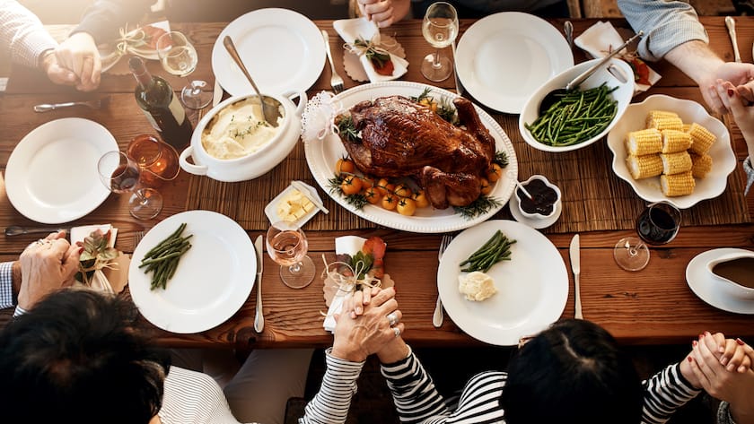 High angle shot of an unrecognizable family saying grace at the dining table on Thanksgiving