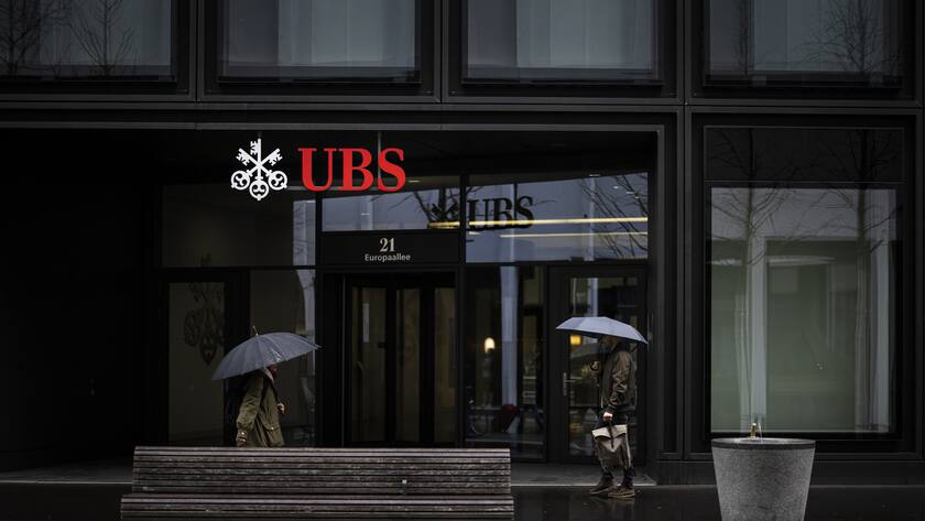 People walk past a logo of the Swiss bank UBS in Zurich, Switzerland, on Friday, March 24, 2023. (KEYSTONE/Michael Buholzer).