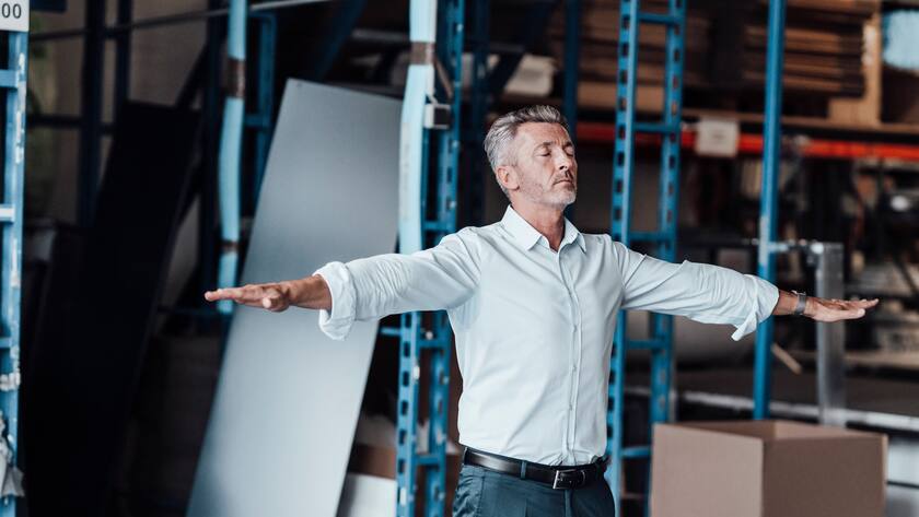 Manager meditiert mitten in der Firma: Yoga hilft auch im Businessumfeld.