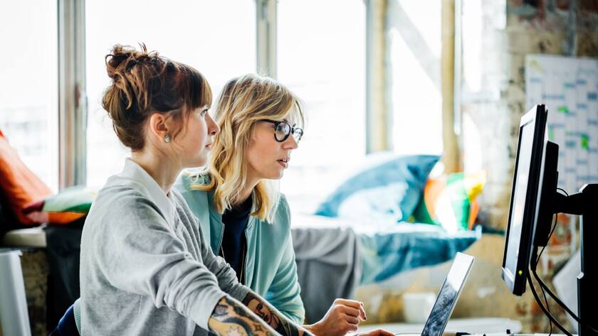 Two casual businesswomen working on a computer
